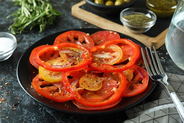 Concept of tasty food with tomato carpaccio on black smokey table