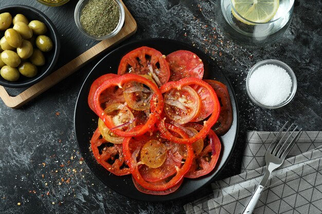 Concept of tasty food with tomato carpaccio on black smokey table