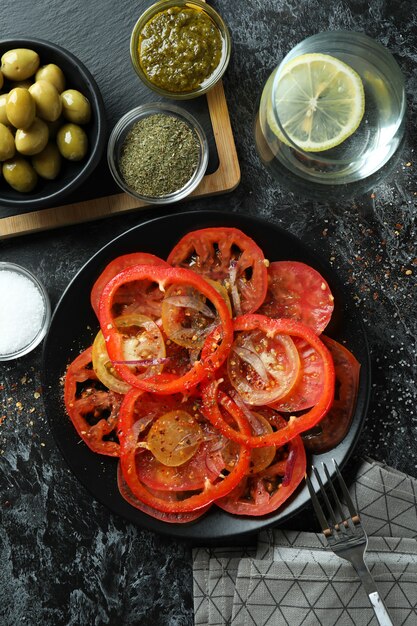 Concept of tasty food with tomato carpaccio on black smokey table