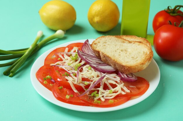 Concept of tasty food with tomato carpaccio on mint background