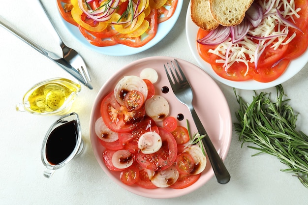 Concept of tasty food with tomato carpaccio on white textured table