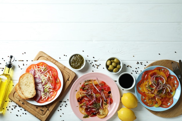 Concept of tasty food with tomato carpaccio on white wooden table