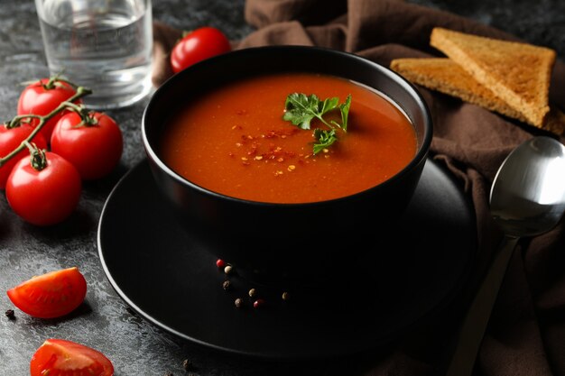 Concept of tasty food with tomato soup on black smokey