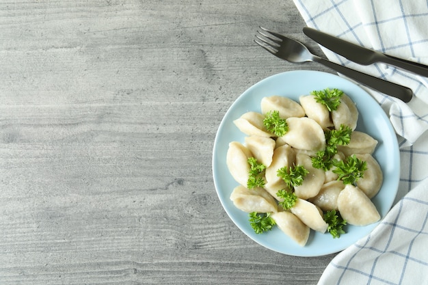 Concept of tasty food with vareniki or pierogi on gray textured table