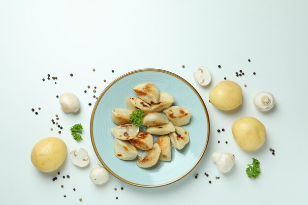 Concept of tasty food with vareniki or pierogi on white surface