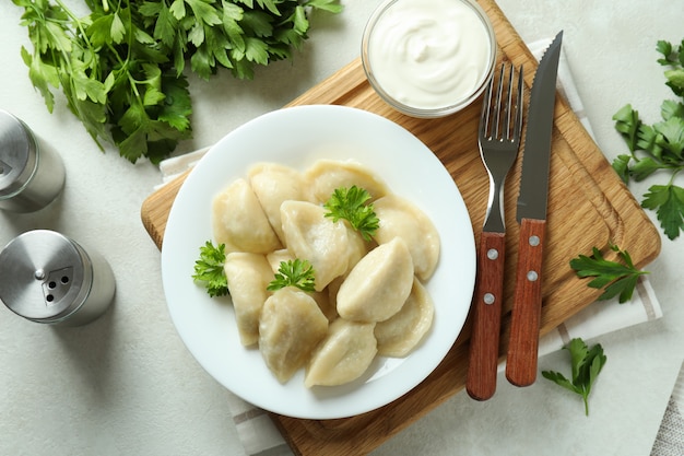 Concept of tasty food with vareniki or pierogi on white textured table