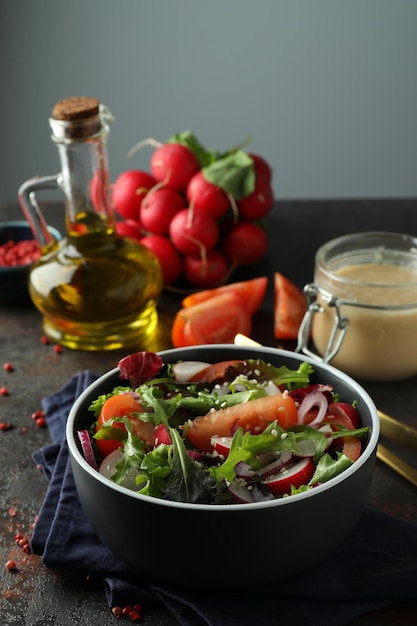 Concept of tasty food with vegetable salad with tahini sauce on dark textured table