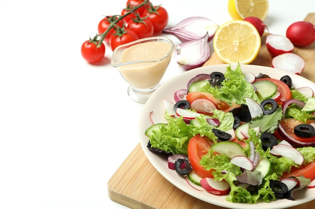 Concept of tasty food with vegetable salad with tahini sauce on white background