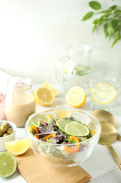 Concept of tasty food with vegetable salad with tahini sauce on white wooden background