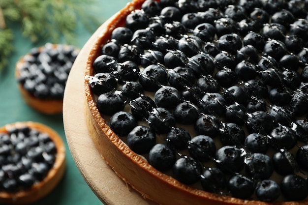 Concept of tasty lunch with blueberry pie on green