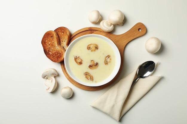 Concept of tasty lunch with bowl of mushroom soup on white