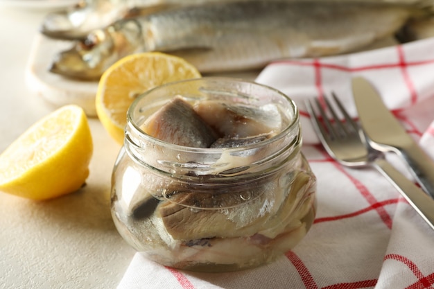 Photo concept of tasty lunch with fresh herring fish on white textured background