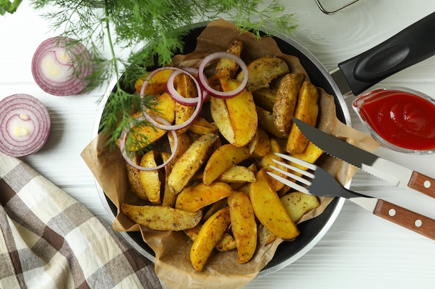 Concept of tasty meal with pan of tasty potato wedges