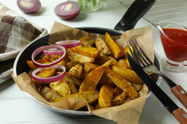 Foto concetto di gustoso pasto con padella di gustosi spicchi di patate