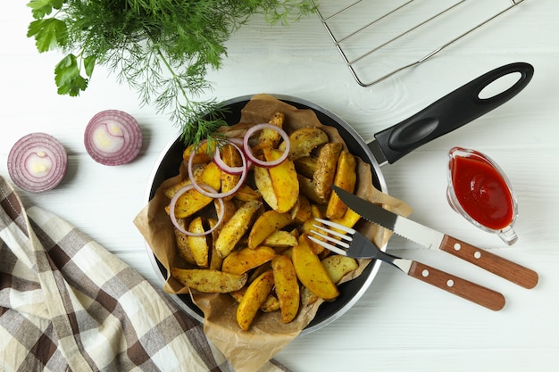 Concept of tasty meal with pan of tasty potato wedges