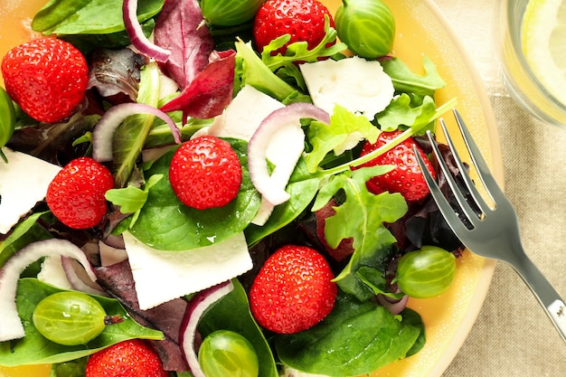 Concept of tasty salad salad with strawberry close up