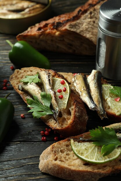 Concept of tasty snack with sandwiches with sprats on wooden background