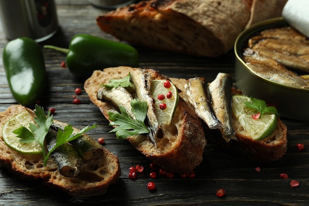 Concetto di gustoso spuntino con panini con spratti su fondo di legno