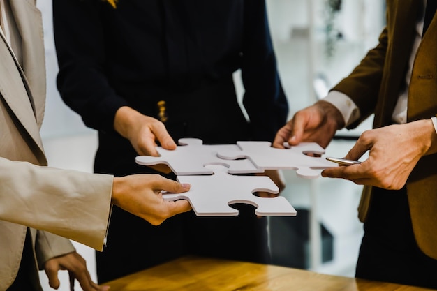 concept of teamwork and partnership hands join puzzle pieces in the office