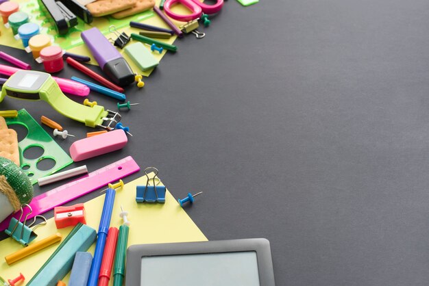 Concept terug naar school kijken krijt cookies briefpapier op zwarte achtergrond.