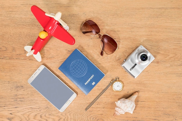 Concept time to go on vacation - toy plane, clock and passport and other items on old wooden table