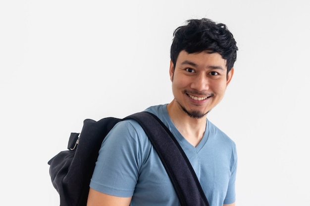 Concept of traveling. Asian man in blue t-shirt and backpack on isolated space.