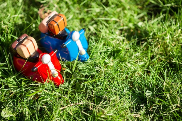春や夏のモペッドでの旅行のコンセプト 太陽の下で緑の芝生の上のモペッドのおもちゃのフィギュア