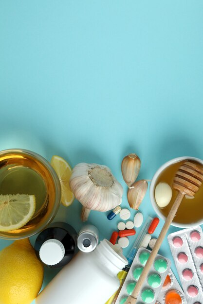 Concept of treatment colds with honey and garlic on blue background