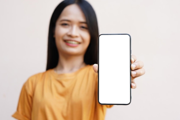 Concept of use of the smartphone A smartphone with a white blank screen in the hands of a woman