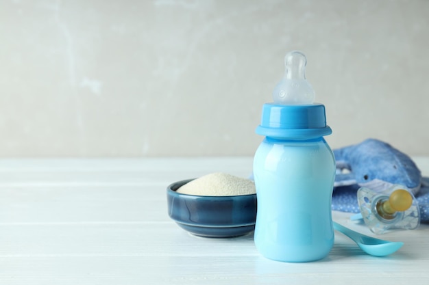 Concept van babyvoeding met melk op witte houten tafel