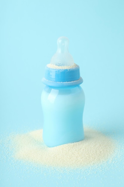 Concept van babyvoeding met Ã€owdered melk op blauwe achtergrond