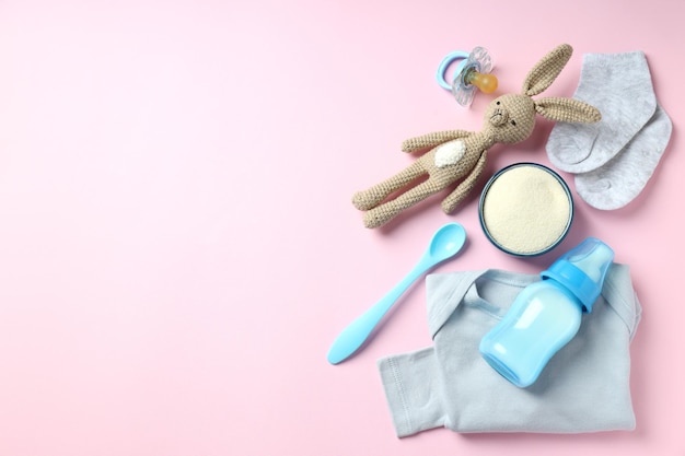 Concept van babyvoeding met €owdered melk op roze achtergrond