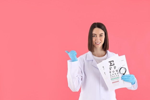 Concept van beroep jonge vrouwelijke arts op roze achtergrond