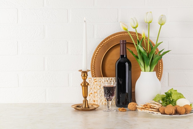 Concept van de Joodse Pascha feestdag Lenteviering regeling met een fles rode wijn matzoth brood een brandende kaars in een kandelaar.