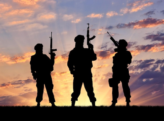 Concept van een terrorist. Silhouetterroristen met geweer bij zonsondergang