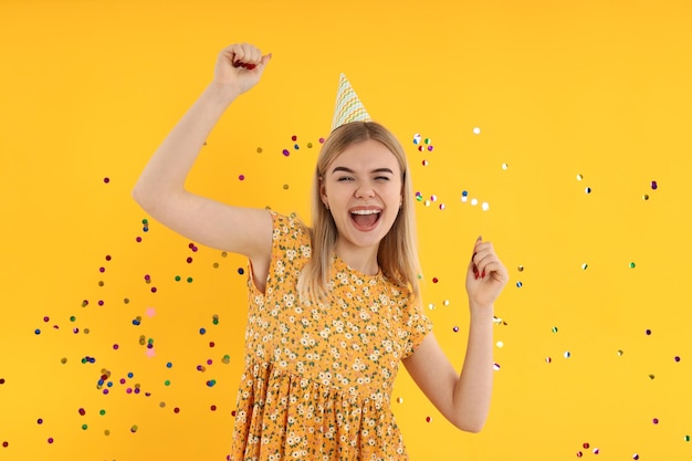 Concept van gelukkige verjaardag met jonge vrouw op gele achtergrond