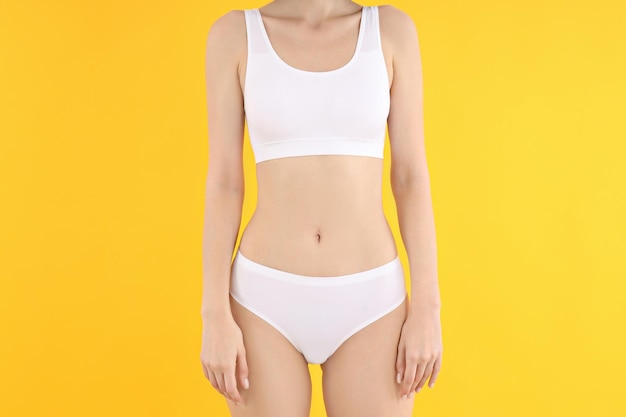 Concept van gewichtsverlies jonge vrouw op gele achtergrond