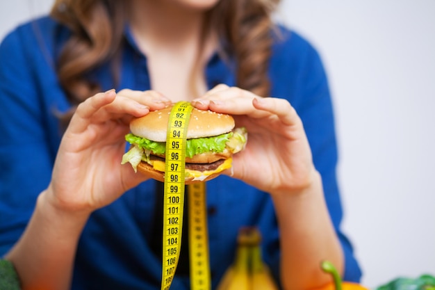 Concept van gezond eten, hamburger met gele meetlint