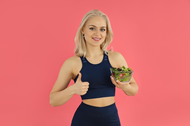 Concept van gezonde levensstijl met sportieve vrouw op roze background