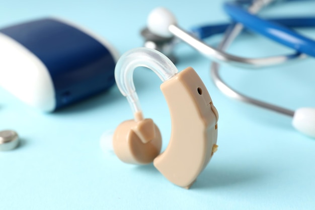Concept van gezondheidszorg met gehoorapparaat op blauwe achtergrond