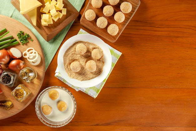 Concept van het bereiden van Braziliaanse snacks kaasvulling kroket bolinha de queijo Bovenaanzicht