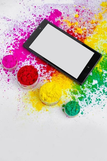 Concept van het Indiase festival Holi multi color39s op vloeren met telefoon en tablet