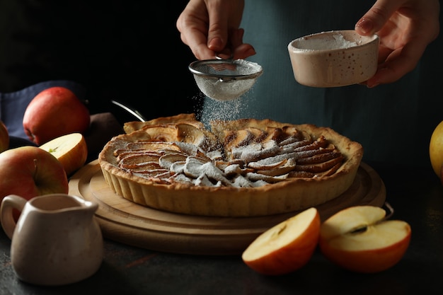 Concept van het koken van appeltaart op donkere achtergrond