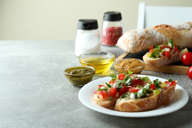 Concept van het koken van bruschetta-snacks op een grijze getextureerde tafel