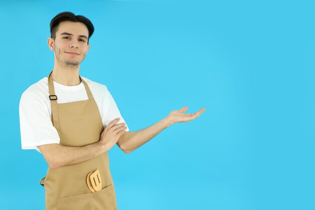 Concept van het koken van jonge man chef-kok op blauwe achtergrond