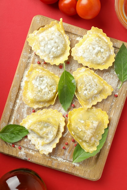 Concept van het koken van ravioli op rode achtergrond