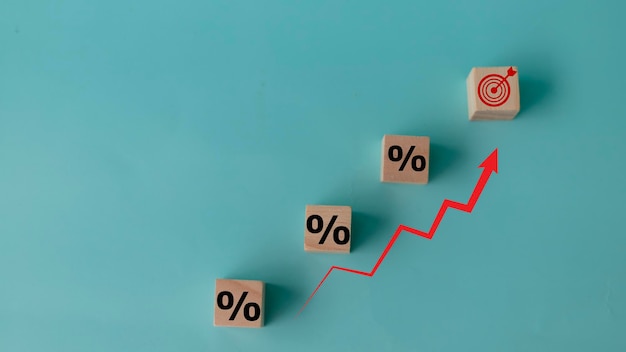 Concept van het verhogen van de omzet Houten kubussen met percentagepictogram en stijgende pijl rood op blauwe achtergrond investeringsgroeidoelstellingen concept