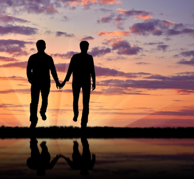 Concept van homoseksuelen. Silhouet gelukkige homomannen lopen hand in hand bij zonsondergang en reflectie in het water