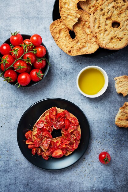 Concept van Italiaans eten. Friselle met tomaat, olie en origano. Bovenaanzicht met kopie ruimte