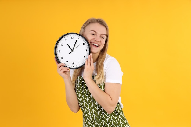 Concept van koken met jonge vrouw op gele achtergrond